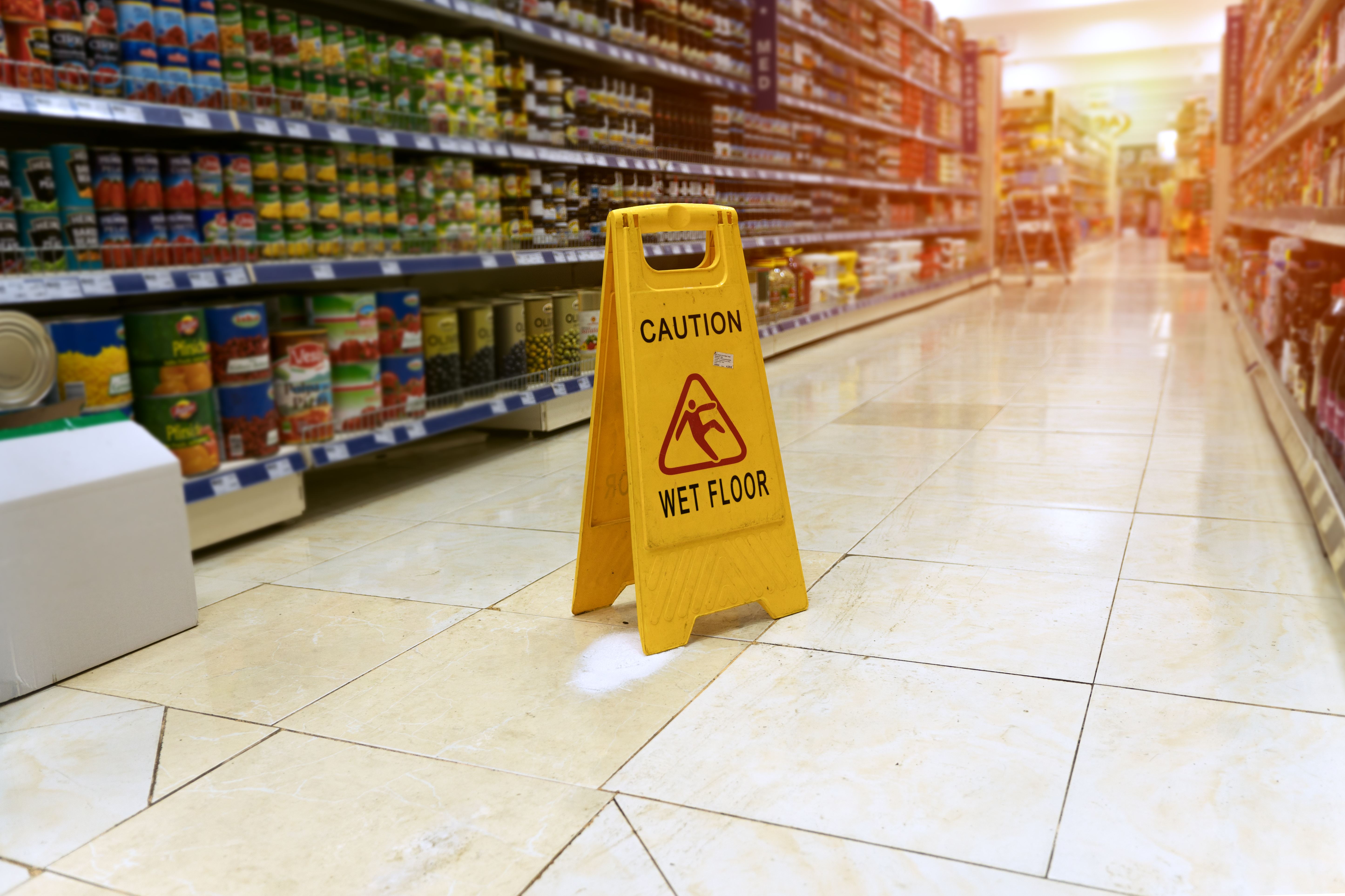 caution wet floor sign in super market aisle